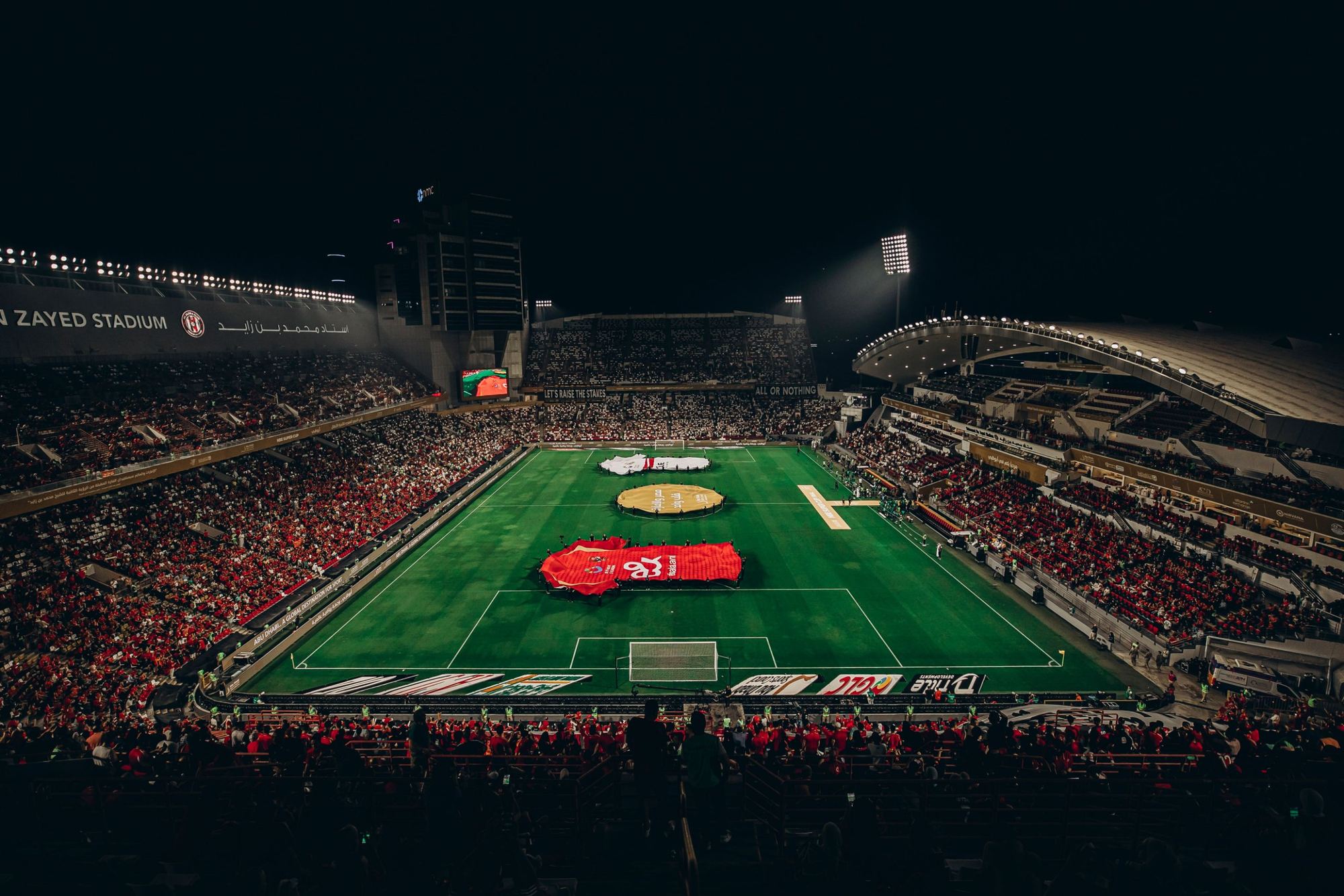 Un stade de football plein, de nuit, avant le coup d'envoi